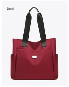 Gedetailleerde weergave van de grote rode oxford tote bag met zwarte riemen
