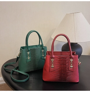 Close-up of crocodile pattern handbags in dark green and burgundy with gold chains