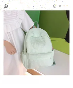Détail du sac à dos vert menthe avec texture à bulles et poche latérale pratique