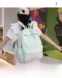 Détail d'un sac à dos scolaire vert clair avec tissu texturé à bulles et grande capacité de rangement