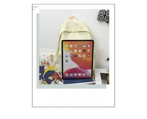 Détail du sac à dos beige texturé montrant sa grande capacité à côté d'un iPad de référence