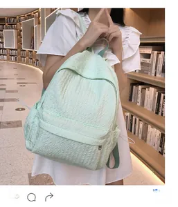 Gros plan du sac à dos vert menthe en tissu plissé avec poches latérales à cordon