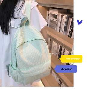 Gros plan d'un sac à dos vert menthe avec texture gaufrée et poche latérale à cordon