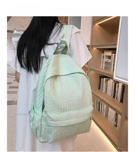 Vue détaillée du sac à dos vert menthe plissé avec des poches latérales à cordon