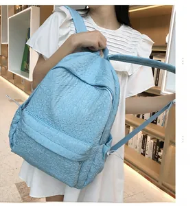 Détail du sac à dos bleu clair avec texture matelassée unique et poche latérale