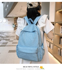 Détail d'un sac à dos matelassé bleu clair avec texture ondulée et plusieurs poches