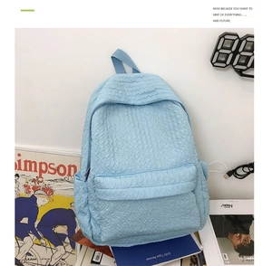 Détail du sac à dos matelassé bleu clair avec coutures ondulées et grandes poches