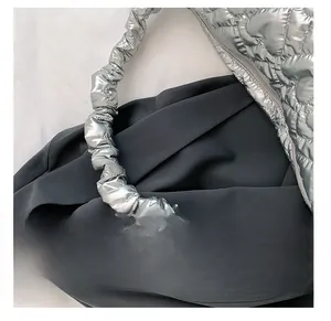 Detail presentation of silver metallic quilted handbag with unique ruched shoulder strap