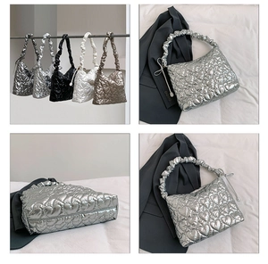 Detailed view of heart-quilted metallic handbags in silver, black, white, and bronze finishes