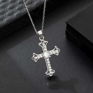 Collana a croce placcata in oro con pietre di zircone scintillanti su sfondo scuro
