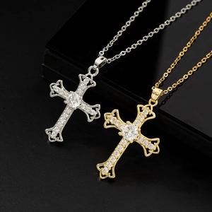 Collane con croce barocca in oro e argento con zirconi lucidi in una confezione regalo nera