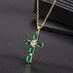 Dettaglio collana a croce placcata oro con pietre verde smeraldo e catena fine a O