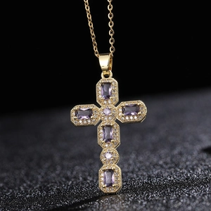 Vue macro du pendentif croix plaqué or avec zircons violets et détails de micro-pavage