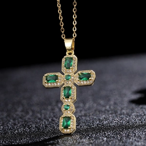 Détail du collier croix plaqué or avec pierres vert émeraude et pavé de zircons