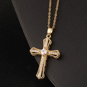 Macro view of a gold-plated cross pendant necklace with sparkling cubic zirconia stones