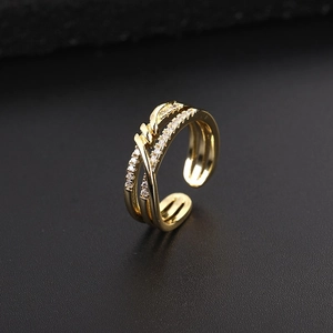 Détail d'une bague multicouche dorée avec zircons micro-pavés et design de corde tordue