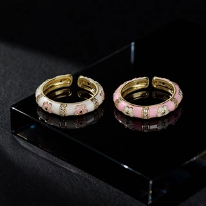 Vintage gold twist rings with ivory and pink enamel floral patterns and sparkling zircons