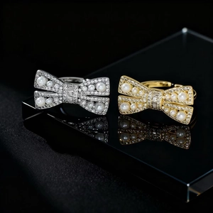 Exquisite bow-shaped pearl rings in silver and gold with sparkling zircon settings