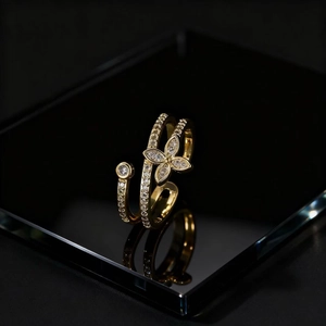 Adjustable gold butterfly open ring with cubic zirconia on black reflective background