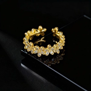 Détail de la bague florale dorée avec micro-pavé de zircons sur surface noire