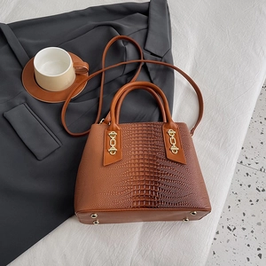 Brown crocodile embossed tote bag with gold chain accent and adjustable shoulder strap
