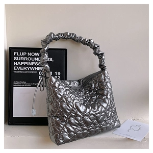 Detailed close-up of heart quilted texture and ruched cloud handle on silver handbag