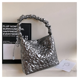 Detail of silver heart-quilted shoulder bag with ruched handle and metallic finish