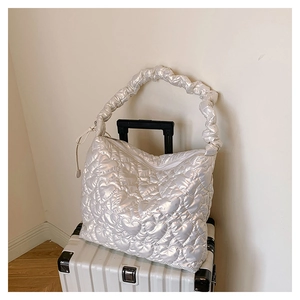 Detailed close-up of heart-shaped quilted pattern on silver large capacity shoulder bag