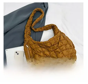 Detail view of brown quilted cloud bag with gold zipper showing large storage capacity