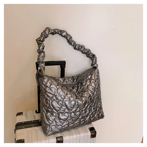 Detail of silver metallic tote featuring heart quilted pattern and ruched shoulder strap