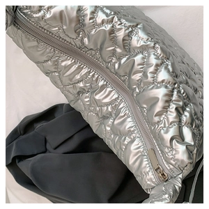 Detail of silver heart-quilted puffer bag showing metallic finish and zipper