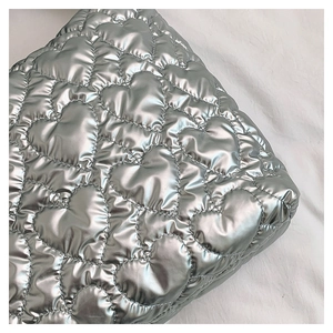 Macro view of silver quilted heart texture on a large capacity stylish tote bag