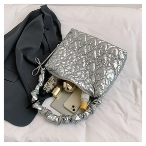 Detailed view of silver heart-quilted handbag showing large interior space and gathered handle