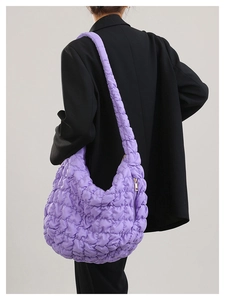 Detailed view of purple quilted puff tote bag with metallic sheen and zipper detail