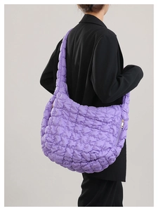 Side view of purple quilted cloud bag featuring a smooth metal zipper and soft padded texture