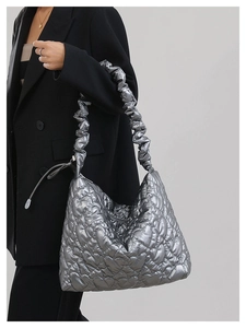 Detail of silver metallic tote bag featuring heart quilting and scrunchie shoulder strap