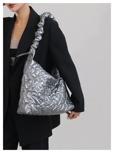 Detail of silver metallic quilted handbag with heart stitching and scrunchie strap