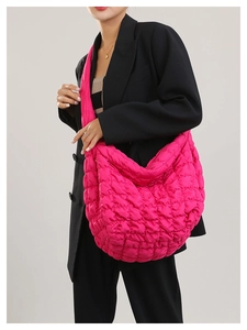 Detailed close-up of vibrant rose red quilted cloud bag showing plush texture on model
