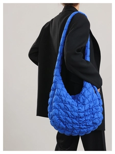 Model view of large royal blue quilted puffer tote bag with stylish bubble texture