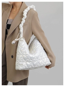 Detail of white heart-quilted nylon tote bag featuring a stylish scrunchie shoulder strap
