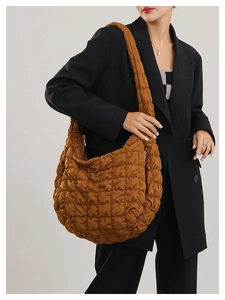 Detail of caramel brown quilted tote bag showing soft nylon texture and wide strap
