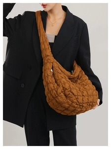 Macro view of brown quilted cloud bag featuring lightweight nylon texture and puffed detail