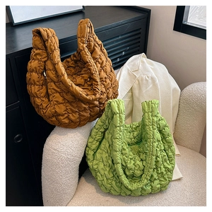 Quilted cloud crossbody bag in caramel and green showing textured puffy fabric