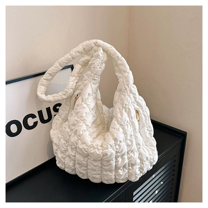 Detail view of a white quilted puffer bag featuring high-quality nylon fabric and gold zipper