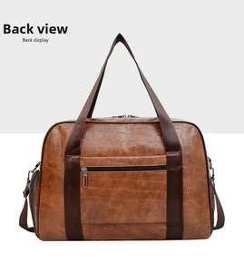 Dettaglio del retro della borsa da viaggio marrone testurizzata coccodrillo con zip in metallo