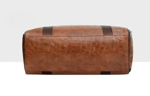 Vista dettagliata del fondo della borsa da viaggio in pelle PU marrone con trama a coccodrillo