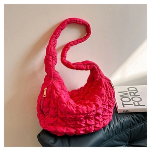 Detail view of hot pink quilted crossbody bag with soft cloud texture and metal zipper