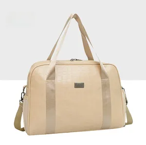 Dettaglio borsa da viaggio in pelle di coccodrillo beige con logo e tasca a rete
