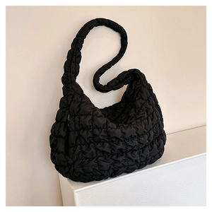 Detail shot of the quilted bubble texture and puffy nylon fabric of the black cloud bag