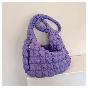 Detail view of purple quilted cloud bag with puffy grid texture and padded shoulder strap